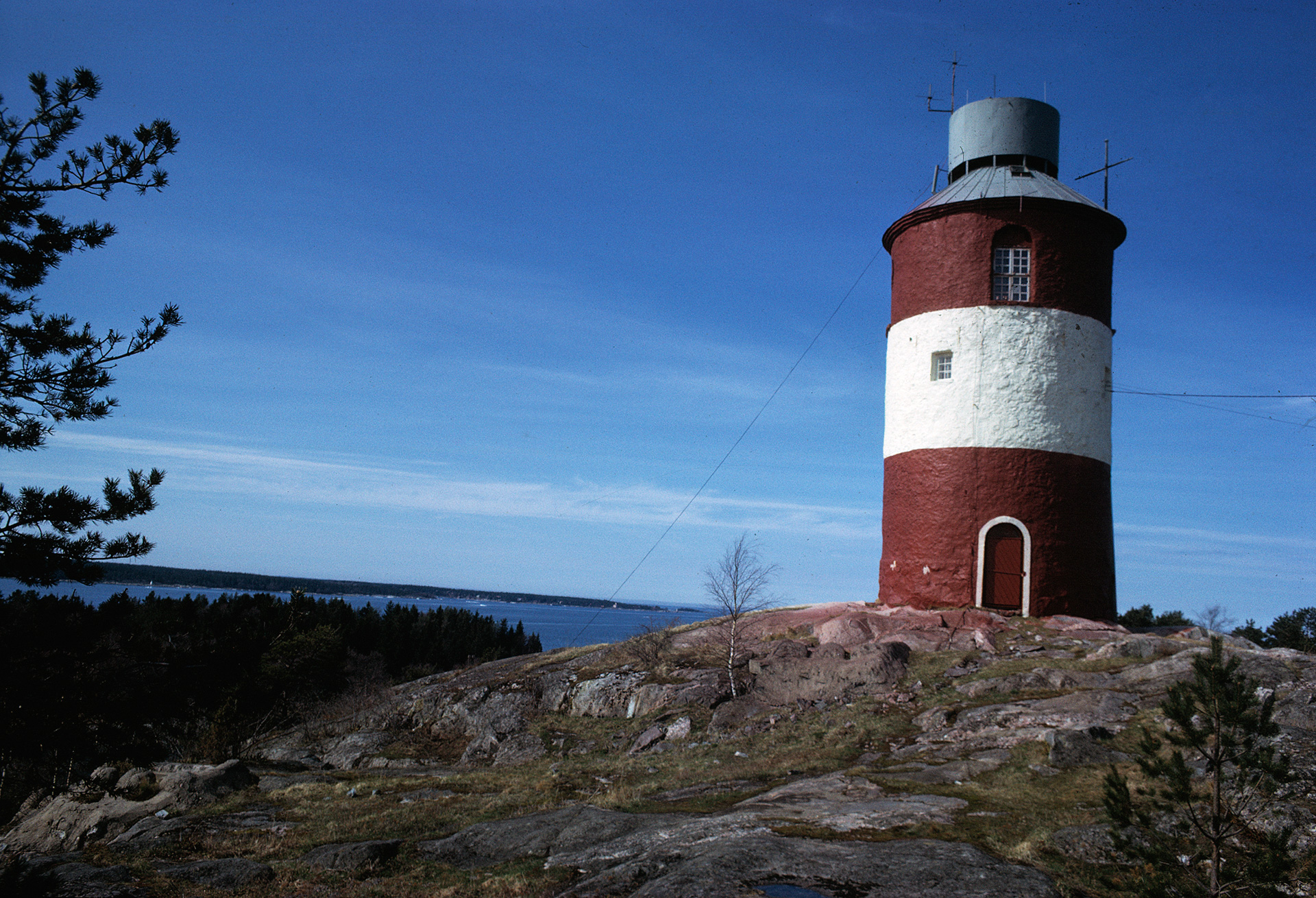 En cylinderformad byggnad står på en klippa vid havet.