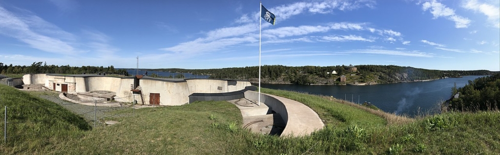 En platt byggnad som står på en kulle men utsikt över havet.