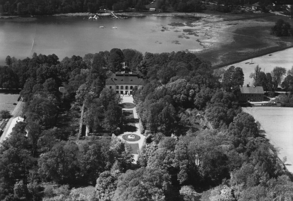 Flygbild över ett slott med vatten bakom