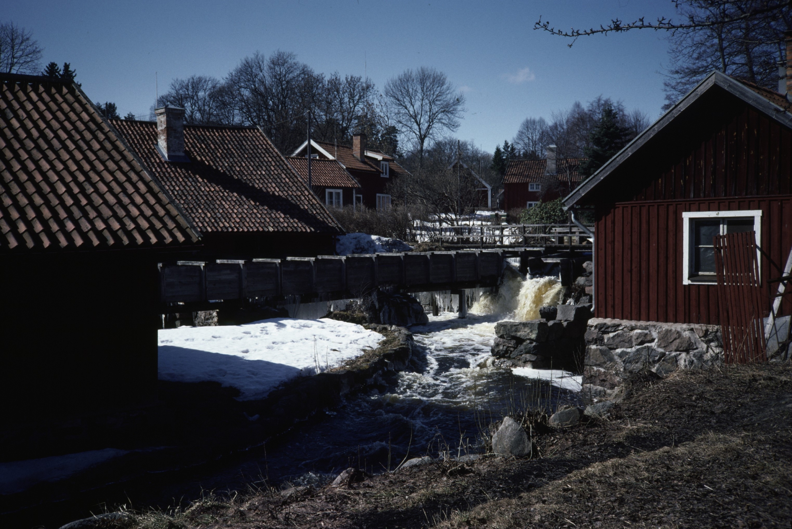 Vatten forsar mellan små röda hus