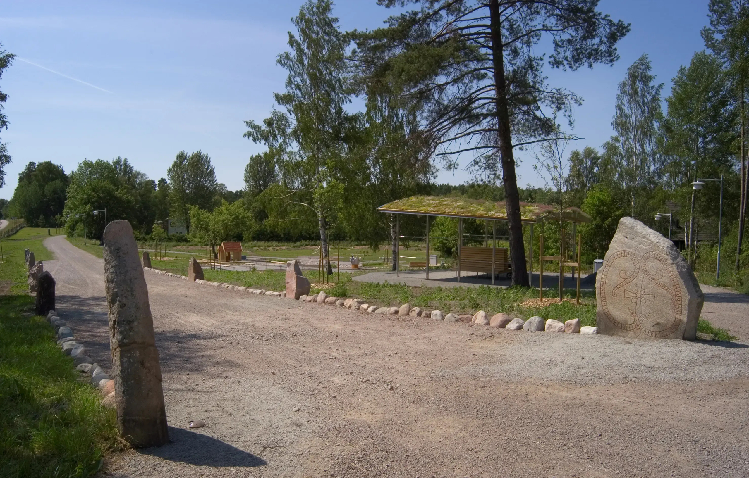 En väg kantad av stenar. Några av dem med runor på.